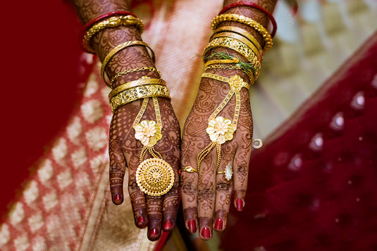 An Indian bride showing her hand jewelry such as hathphool, golden bracelets, golden bangle bracelets and tradition kadas. 