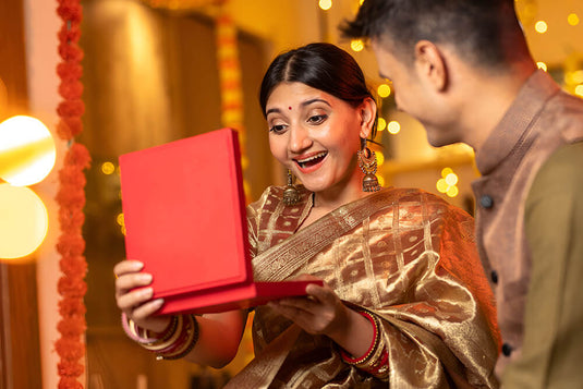 A woman being gifted a jewelry by her loved one on Diwali occasion, such as rings, necklace and bangle bracelets. 