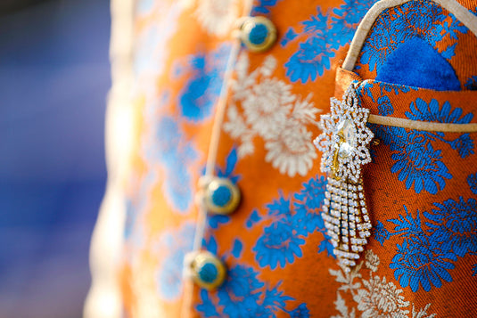 A must have sherwani brooch that is elevating the traditional look, being pinned to the chest of an Indian man. 